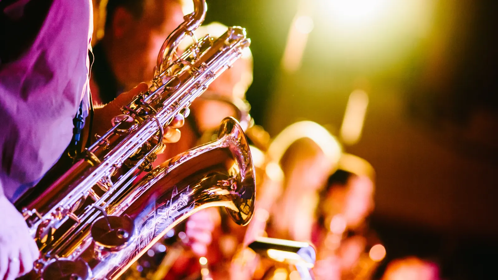 Saxophonists performing under warm stage lights