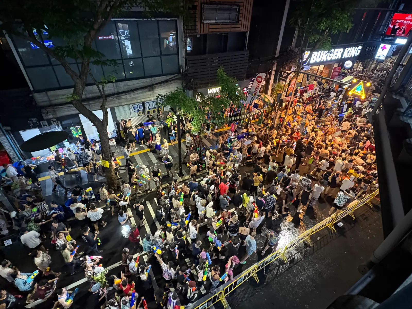 Crowds with water guns filling Si Lom Road at night during Songkran, seen from above