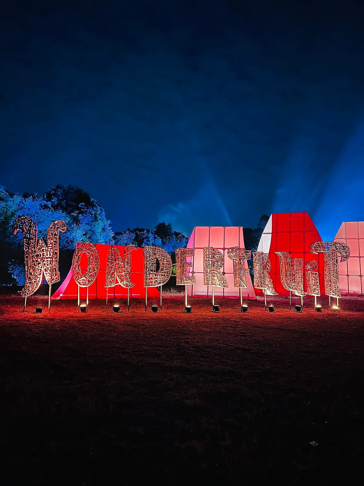 The illuminated welcome sign at Wonderfruit festival at night