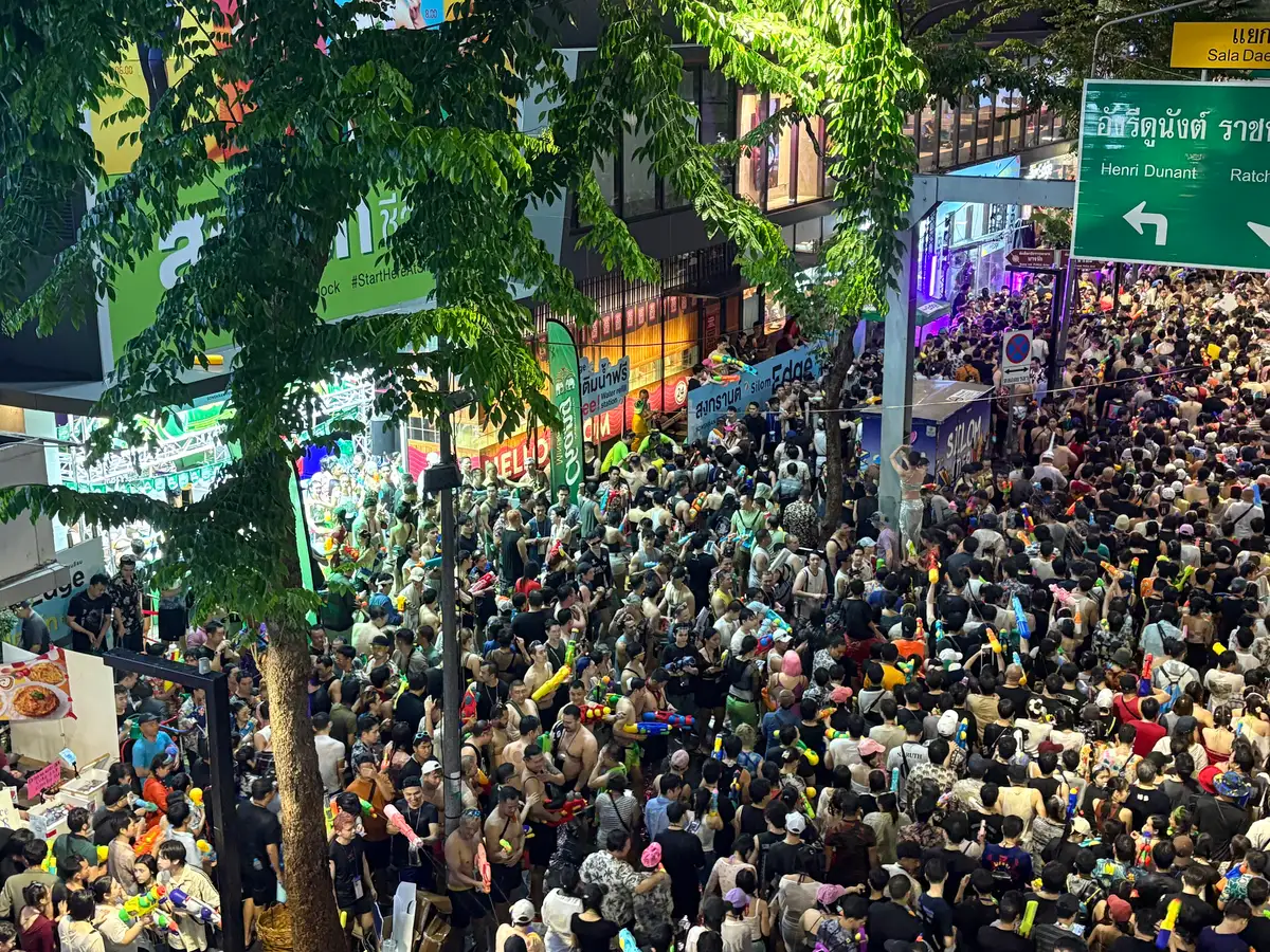 Packed crowd with water guns at the Sala Daeng end of Si Lom Road during Songkran 2025