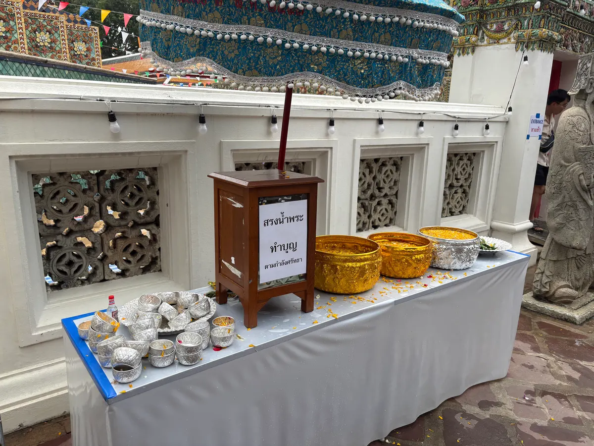 Worshippers bathing Buddha images with water at Wat Pho during Songkran