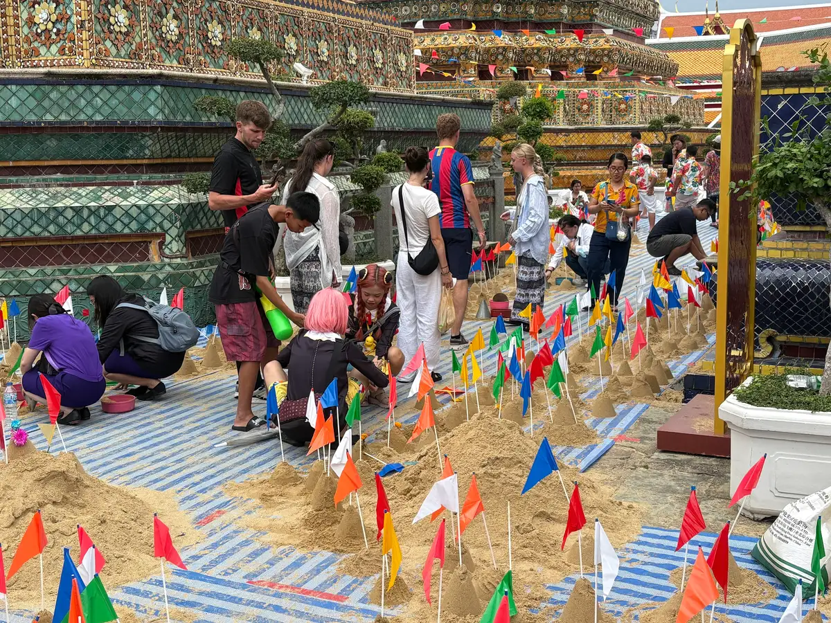 Sand stupas decorated with flags in the grounds of Wat Pho during Songkran